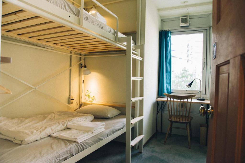 White bunk bed with a workspace and a large window at Nui. HOSTEL & BAR LOUNGE
