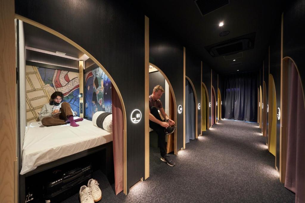 Large pod rooms with curtains, down a hallway in Resol Postel in Asakusa Tokyo