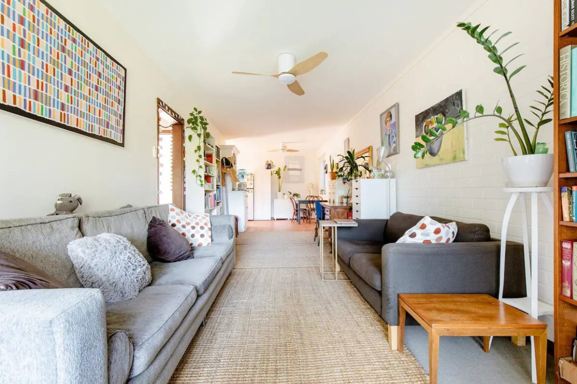 Vibrant living room with loads of couches, art and pants.