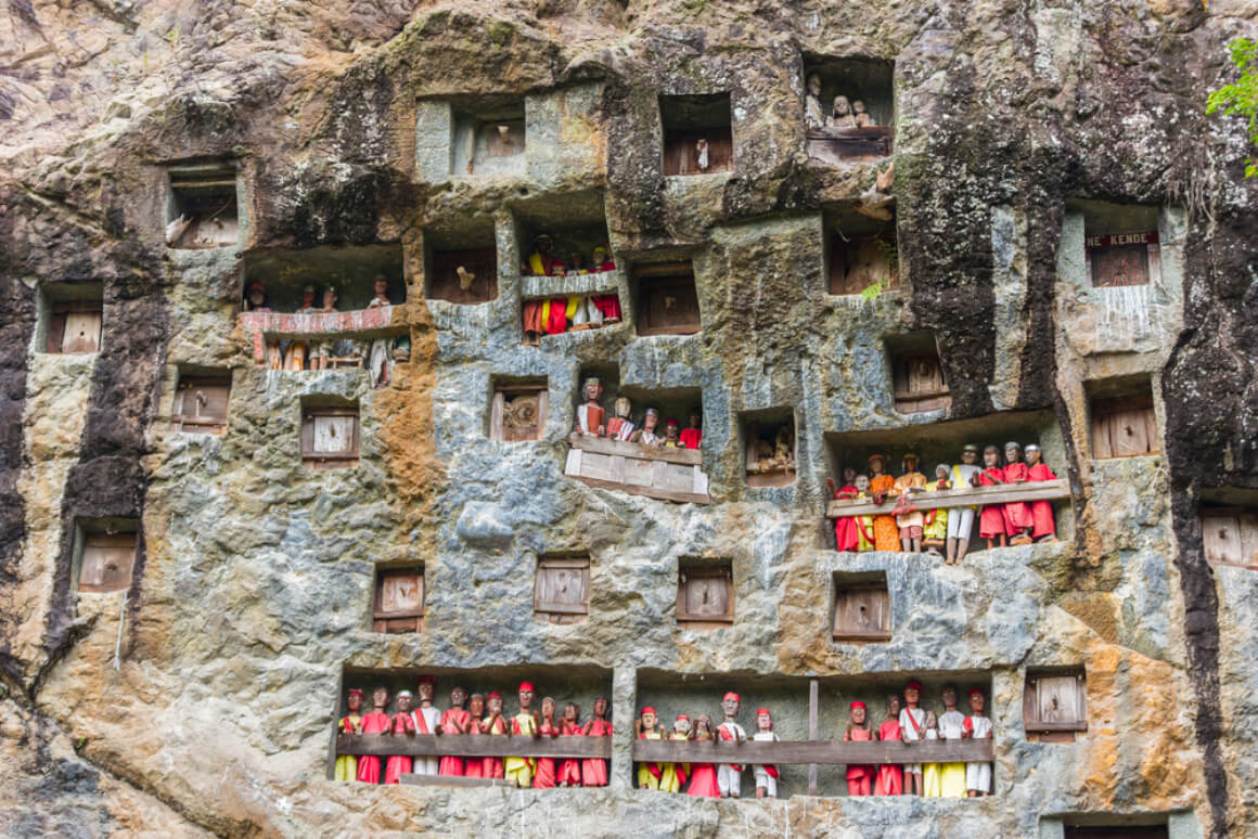 People standing in a traditional building made of rocks in Tana Toraja, South Sulawesi