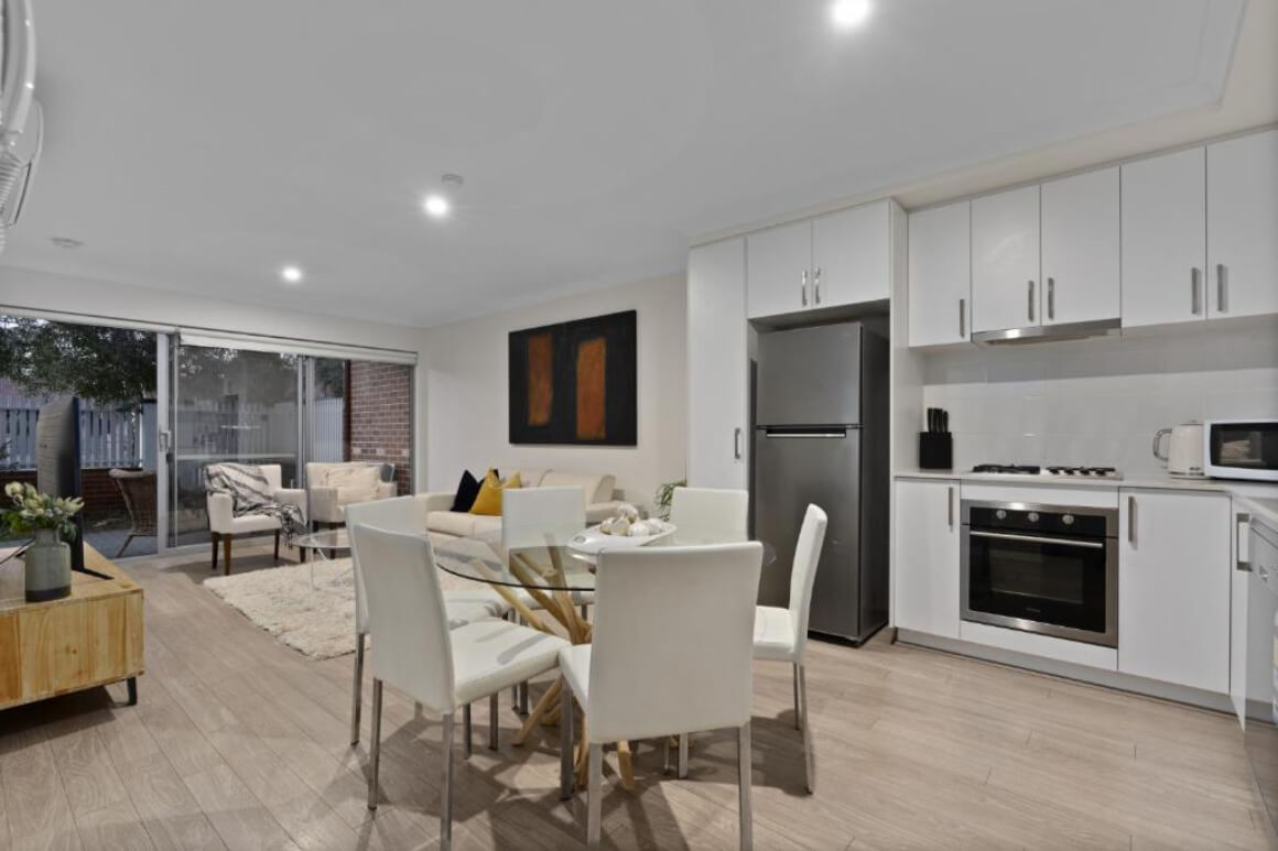 Modern kitchen, lounge and dining area. Sliding door at the back that goes out onto a patio.