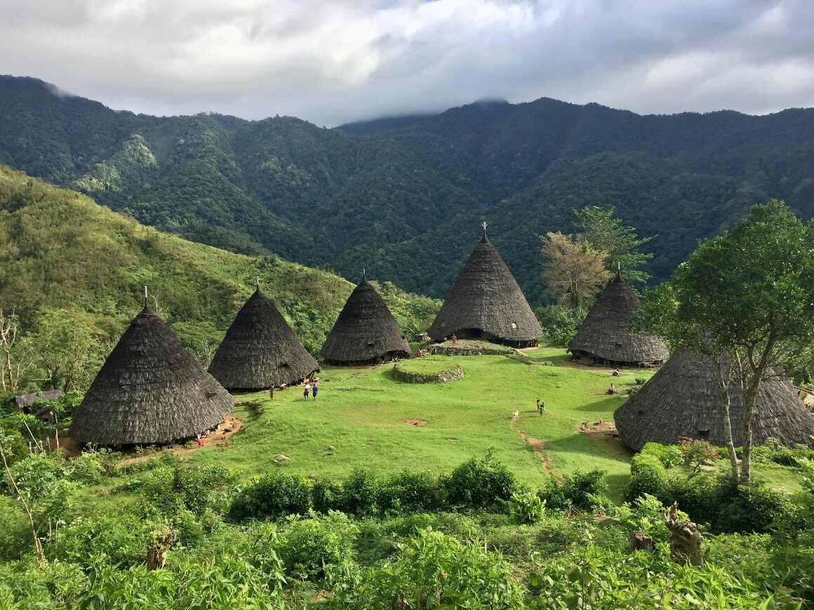 Mbaru Niang in a large valley surrounded by mountains in Wae Rebo Village, Flores