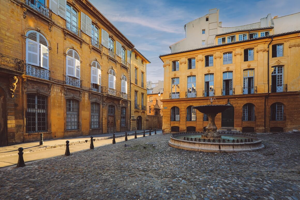 View of Provence typical city Aix en Provence with old house facade and famous old fountain in the morning