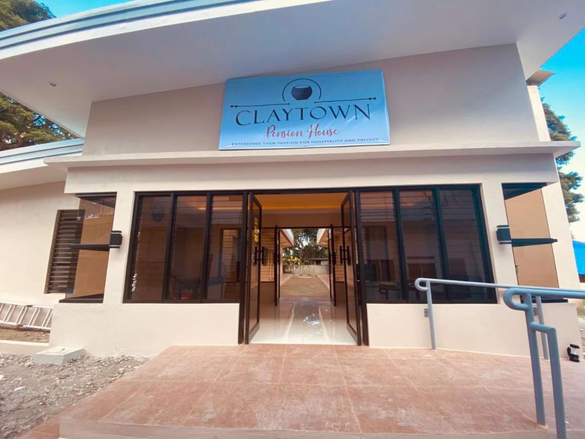 Claytown Pension House entrance with a sign and a glass door