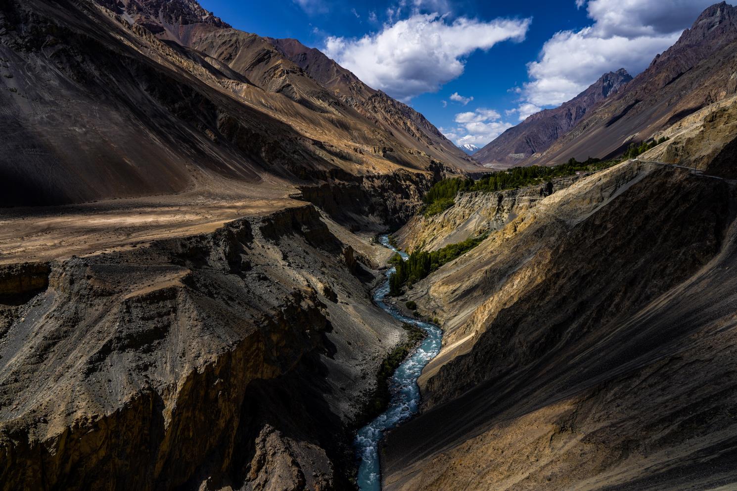 bright blue river snaking through a dry rocky gorge in a remote valley in northern pakistan