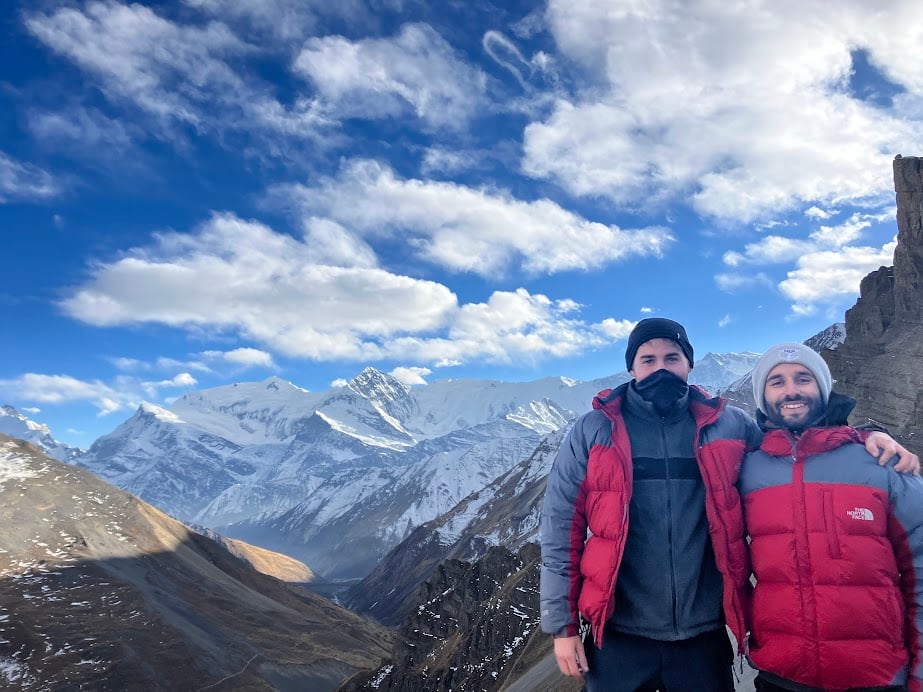 two hikers standing at the top of a high pass in the annapurna region of nepal