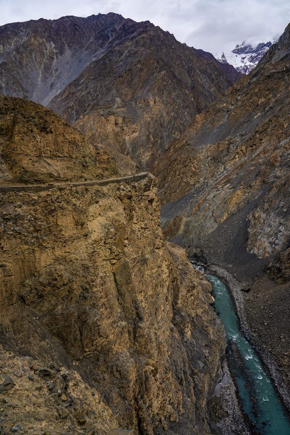 view from an extremely deep gorge in shimshal valley above a thin bright blue river