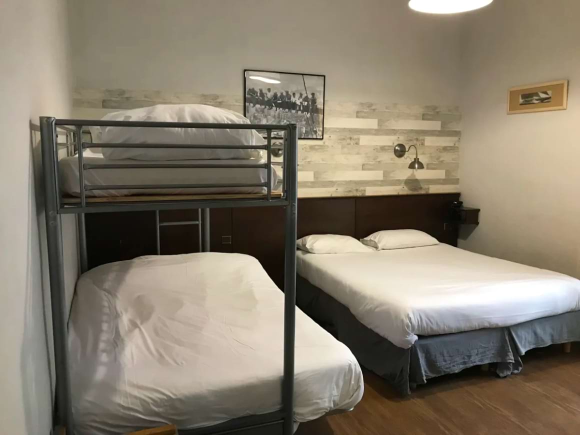 Bunk bed and a queen bed in a  room at Hotel des Ambassadeurs