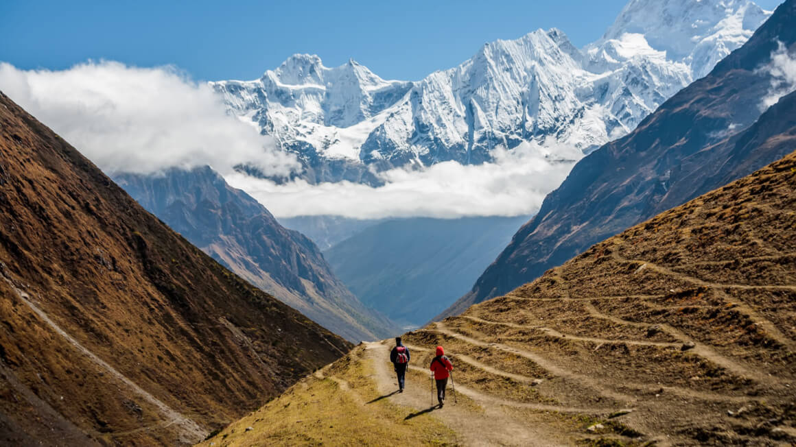 two people trekking on a high altitude pass in nepal on the manaslu circuit