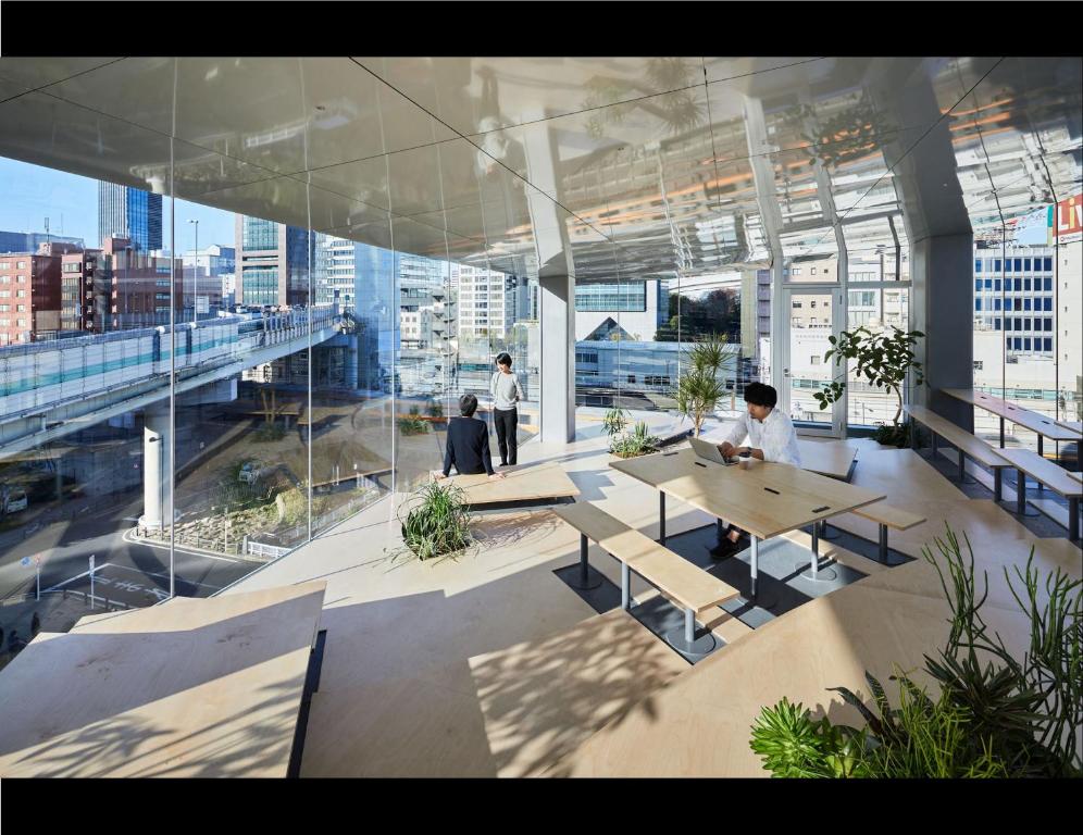 3 persons in a workspace with floor to ceiling glass windows surrounded by buildings in nine hours Suidobashi