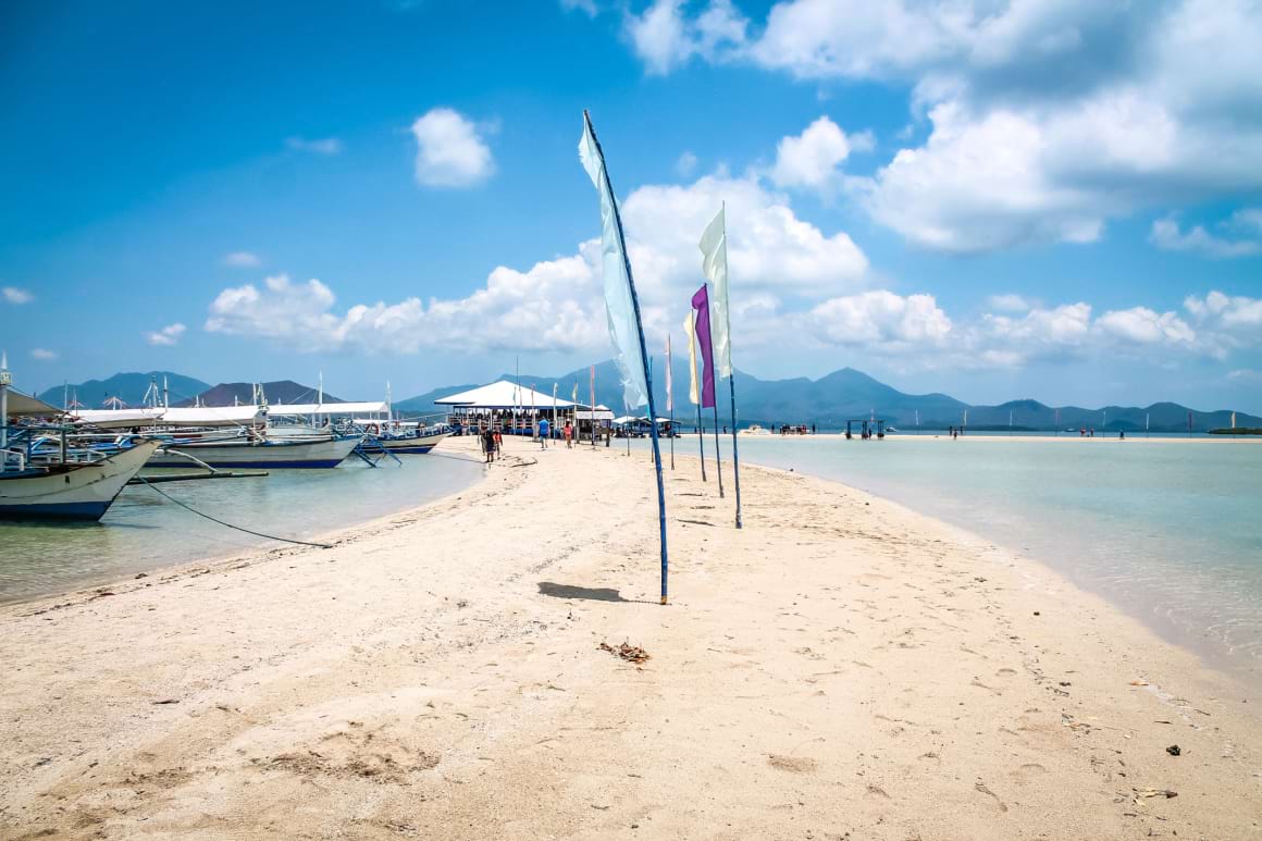 beach with boats lined on the shore in Luli Island, Puerto Princesa