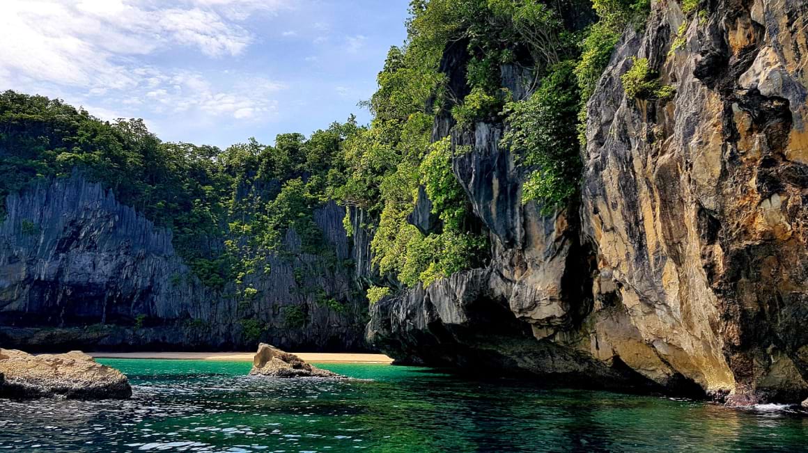 Sabang beach with towering limestone cliffs in Puerto Princesa