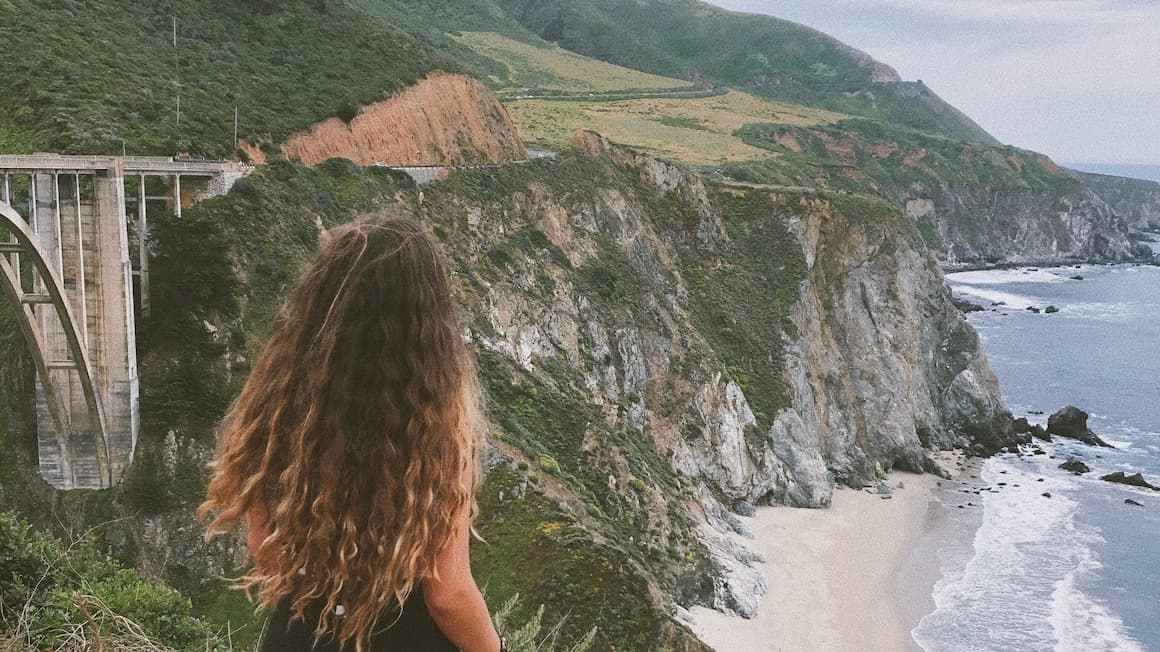 a girl looking at an amazing view of big sur california United States of America.