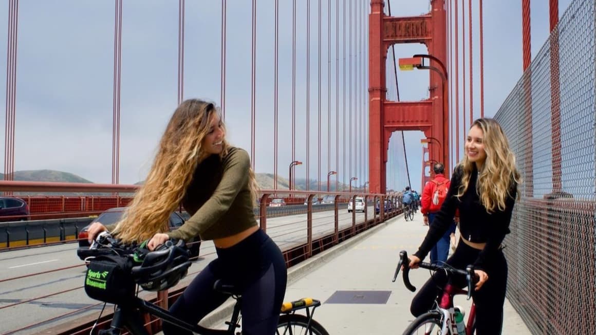 Two girls riding bikes across The Golden Gate Bridge United States of America.