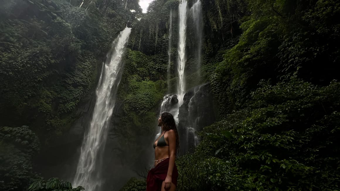 A girl standing near Sekumpul Waterfall in bali indonesia 