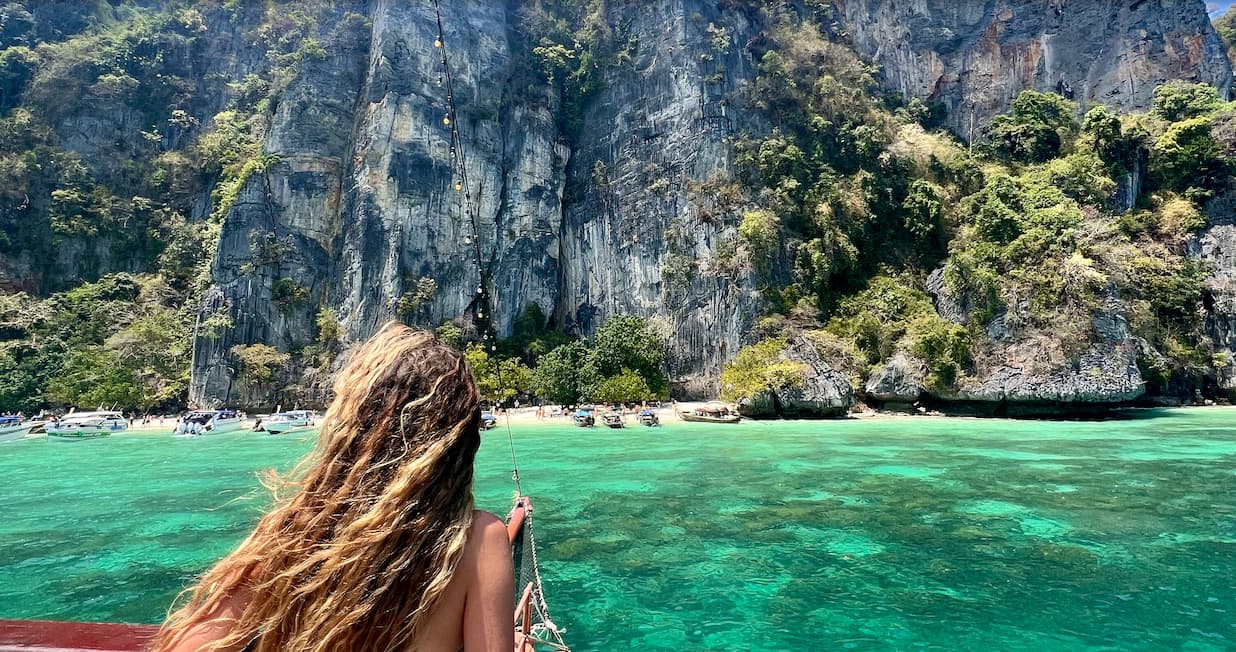 a girl looking out of a boat with a view of the ocean on an island in  thailand.