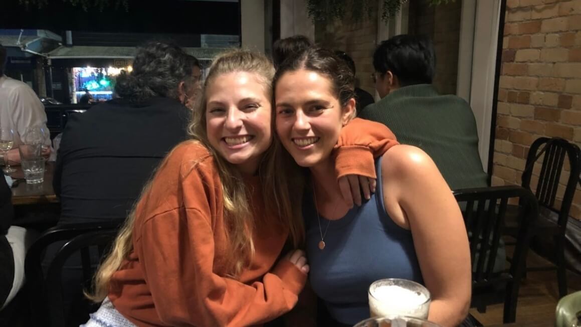 Two happy girls hugging at a bar