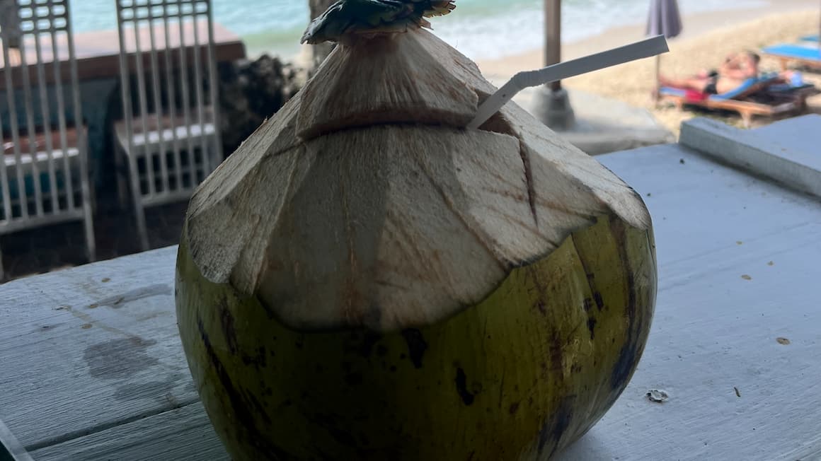 a coconut full of coconut water at a beach bar in Bali