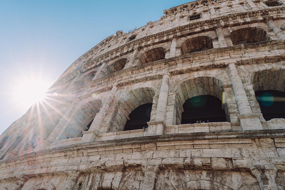 A sunstar peaking around the colosseum in Rome, Italy