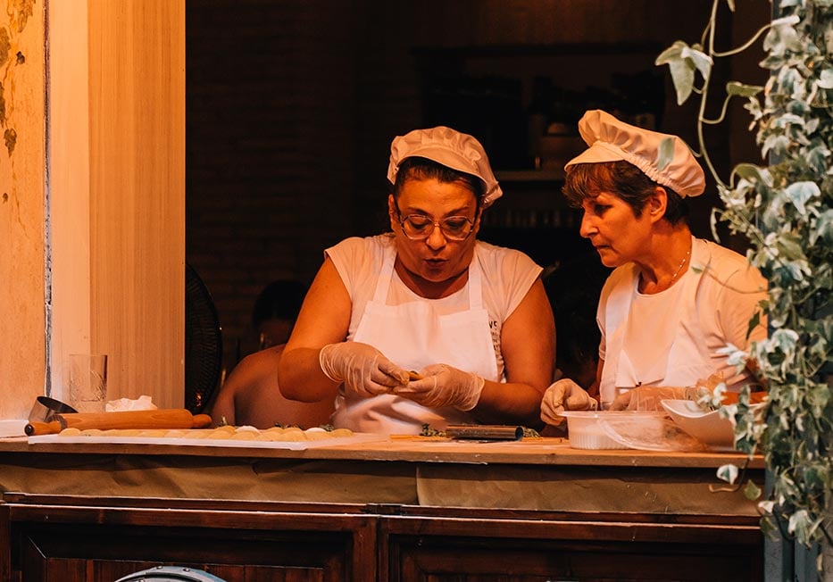 Two women making pasta and italian food in Rome, Italy.