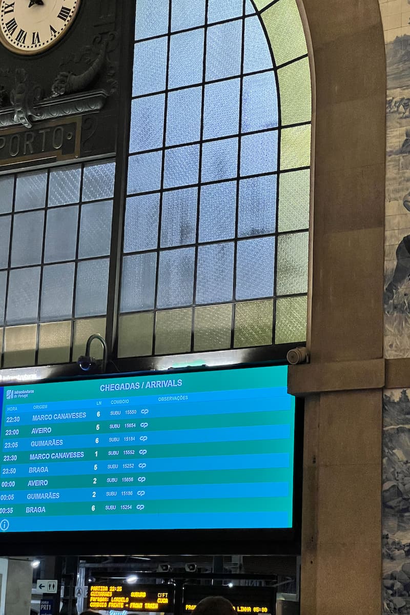 a metro station in porto, portugal with a screen showing the train arrival times