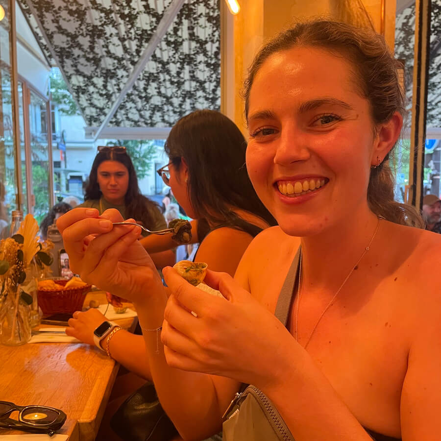 Girl at a restaurant in France about to try snails
