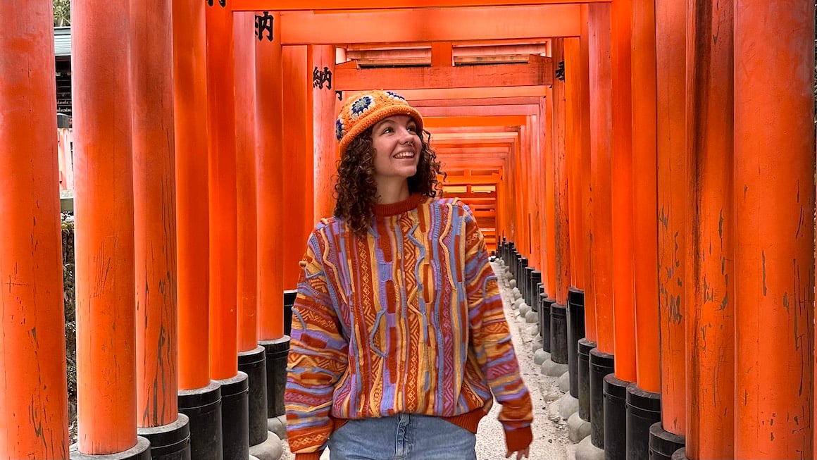 Girl walking through the wandering Torii gate pathways in Kyoto, Japan.