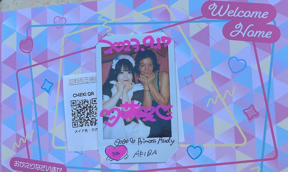 Japanese girl and American girl smile for cute polaroid at maid cafe in Tokyo, Japan.