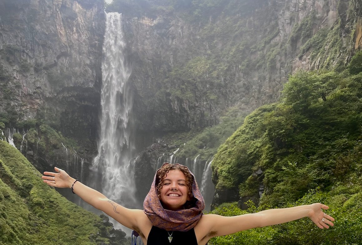 Girl posing for photo in front of Japan's tallest waterfall, Kegon Falls.
