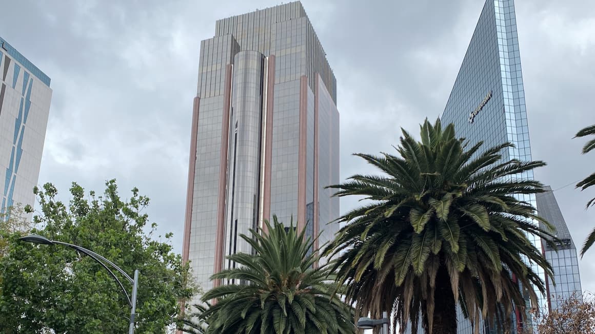 tall buildings in the center of mexico city accompanied by palm trees