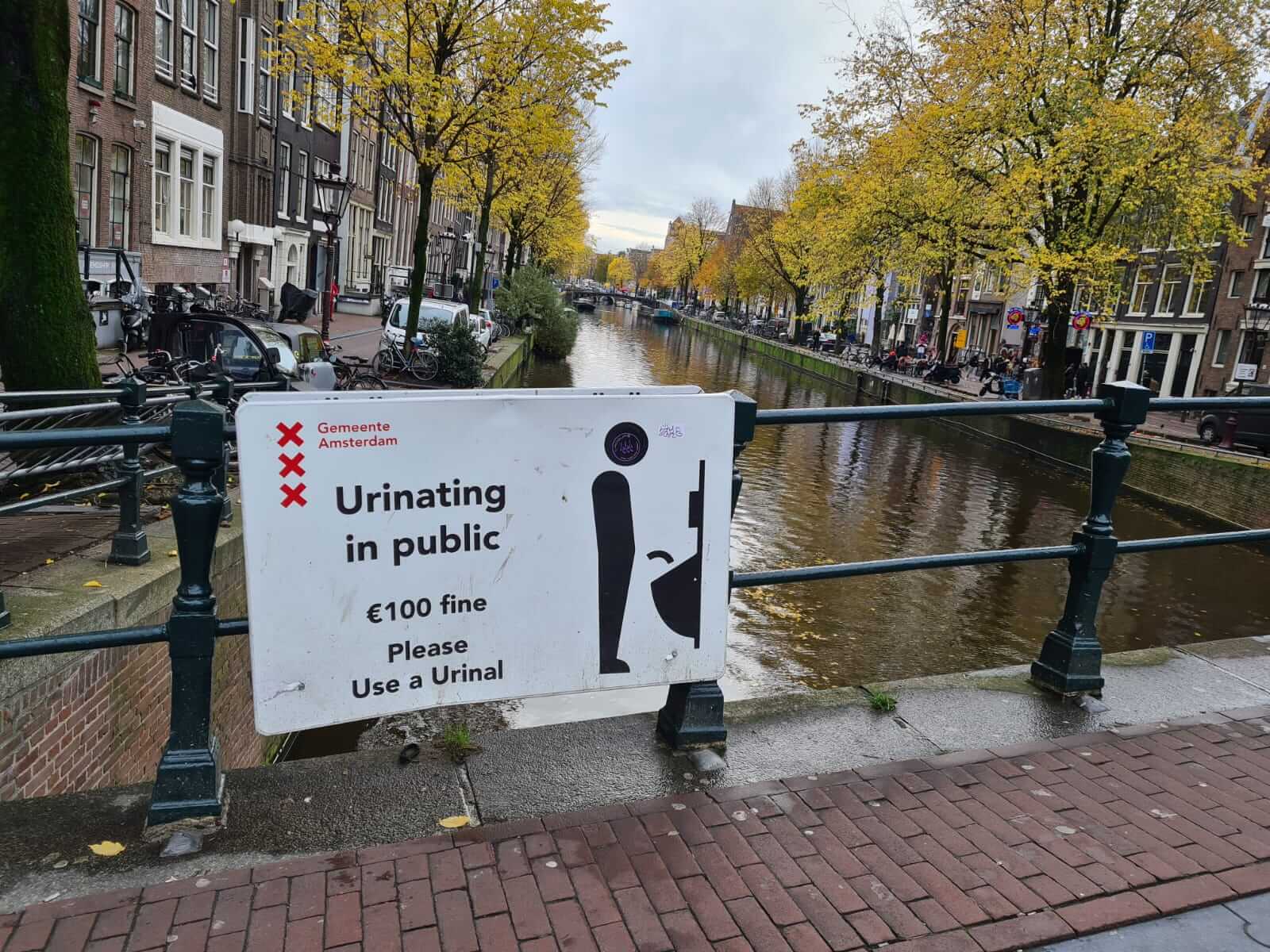 Sign warning of a fine for urinating in public on a bridge in the Red Light District, De Wallen in Amsterdam