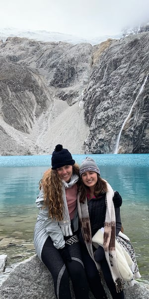 two girls at a lake in Peru with mountains in the background 