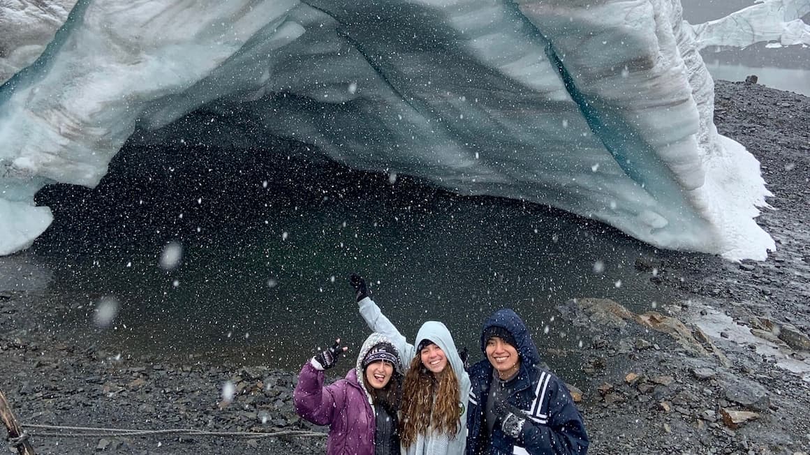 a group of friends in front of a glacier in peru
