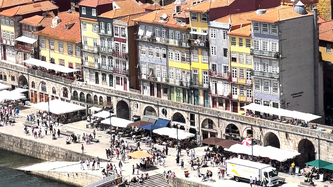 The busy streets of Porto with traditional Portuguese orange-roof houses in the background