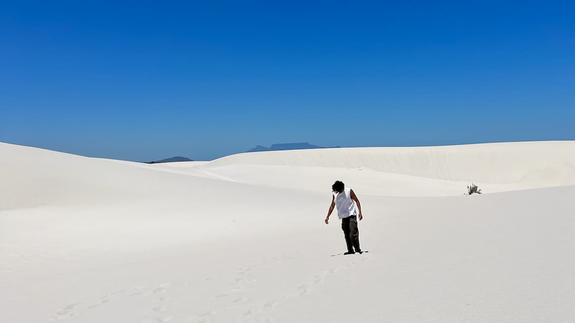 a guy standing in the middle of sand dunes n Cape Town, South Africa 