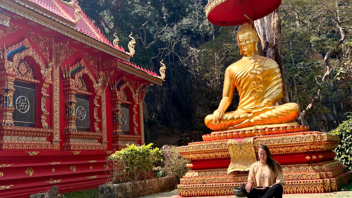 a girl meditating at a temple in thailand
