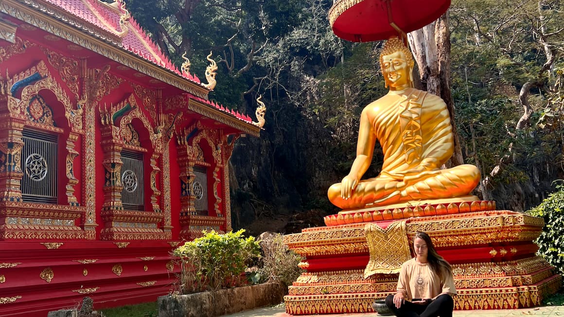 a girl meditating at a temple in thailand 