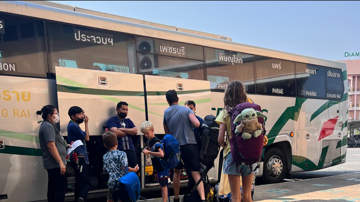 a family getting on to a bus in northern thailand 