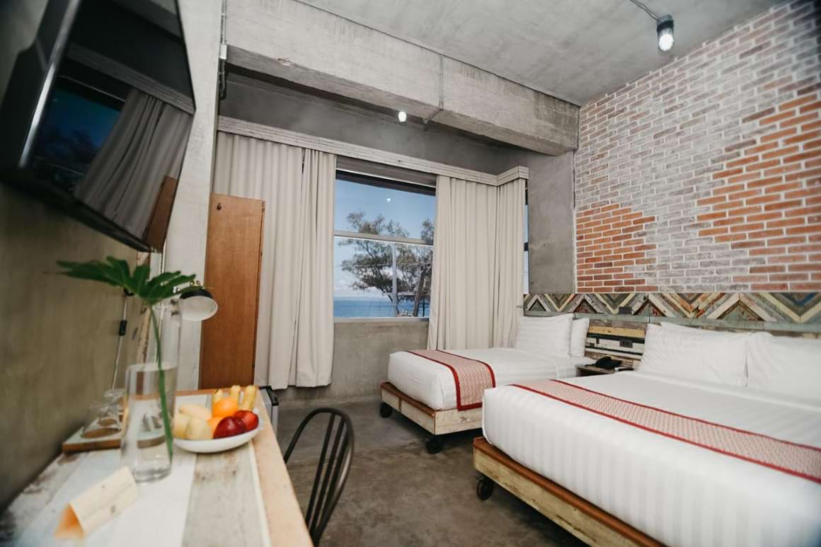 A queen bed and a twin bed, tv, and a seating area in The Bricks Hotel