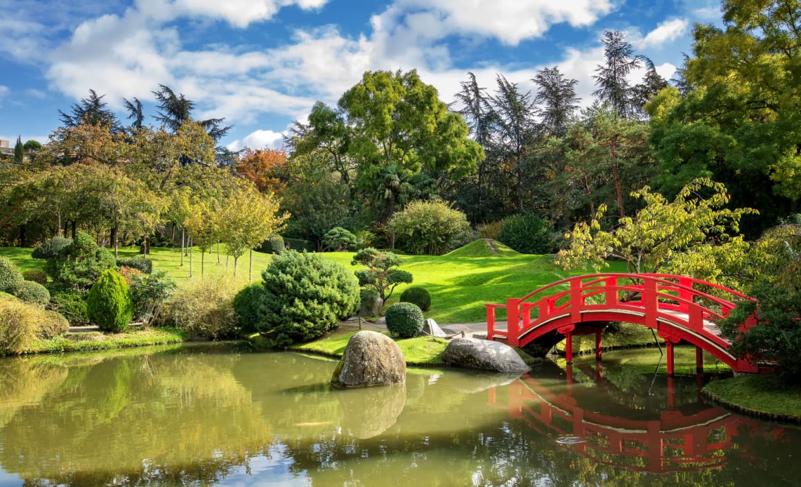 a red bridge crossing a pond in the Japanese Garden Compans Caffarelli in Les Minimes, Toulouse