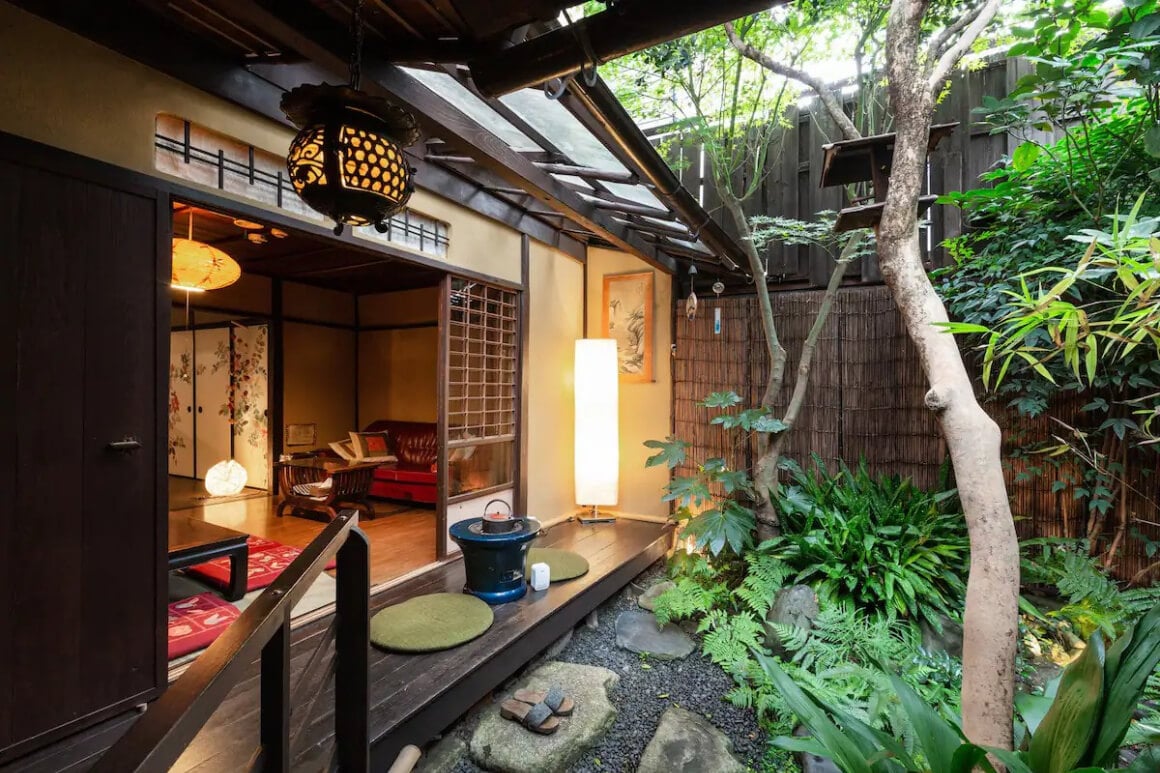 Room in a 100-Year-Old Machiya Guest House with tatami mats and a low wooden table with cushions overlooking a beautiful garden 