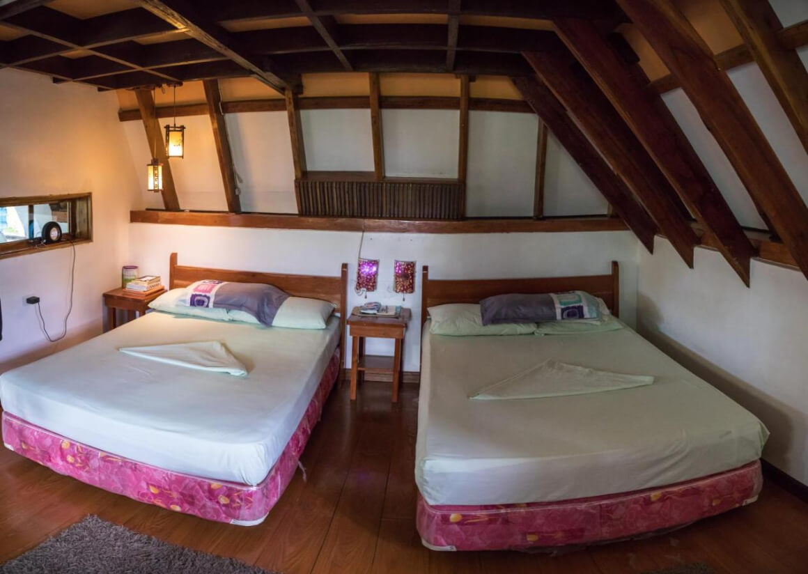 two queen size beds in a room with wooden ceiling in AABANA Beach & Watersport Resort