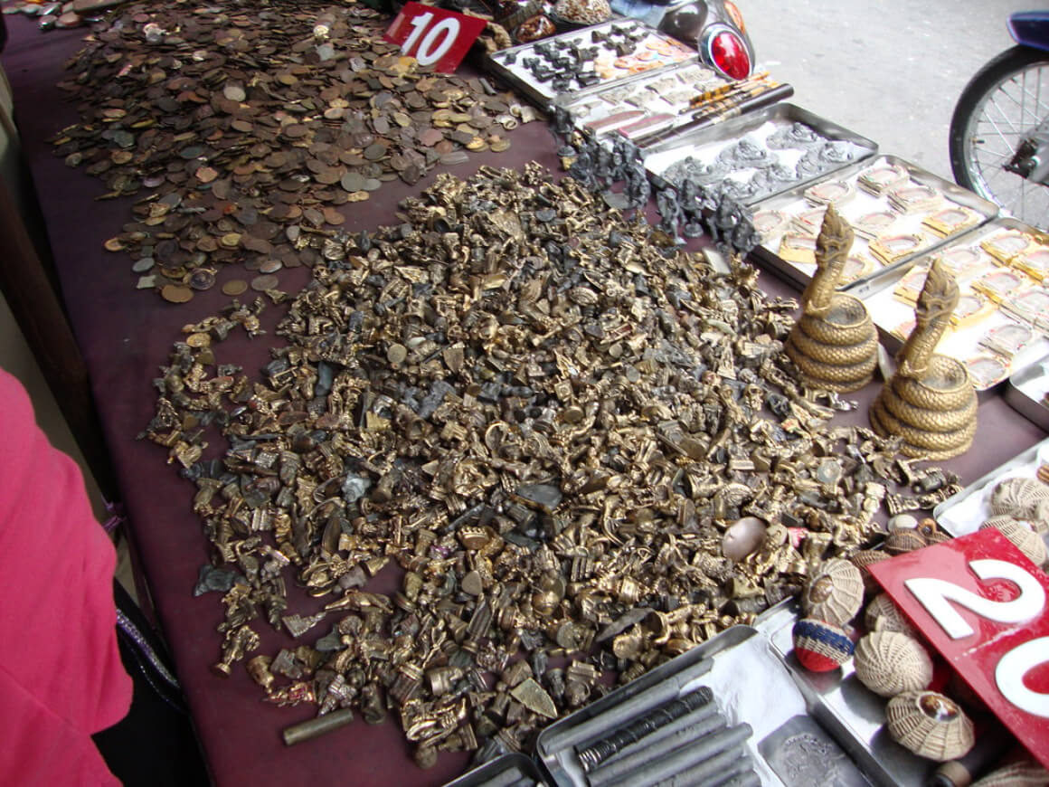 A stall at Amulet Market in Bangkok showing an array of amulets, figurines, and other talismans.