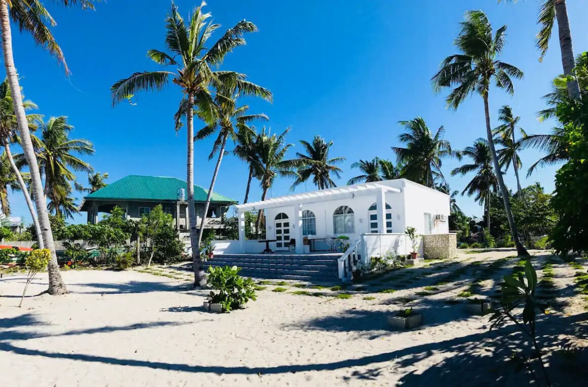 Casa Nova's bangallow nestled on a sandy beach surrounded by palm trees 