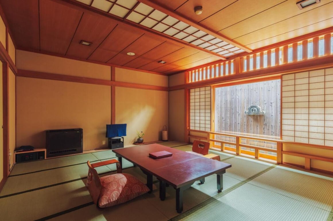 living room with a wooden table and four chairs in Ryokan Motonago, Hyoto