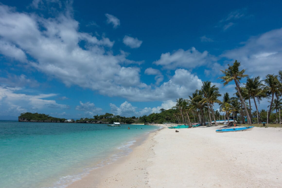 Langob Beach's coastline with serene turquoise water, white sand, and palm trees 