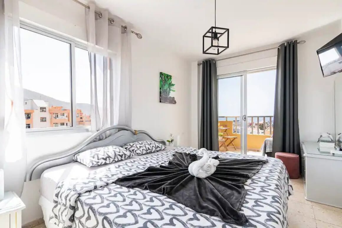 Comfy, bright bedroom with sliding doors out to balcony with view of the city