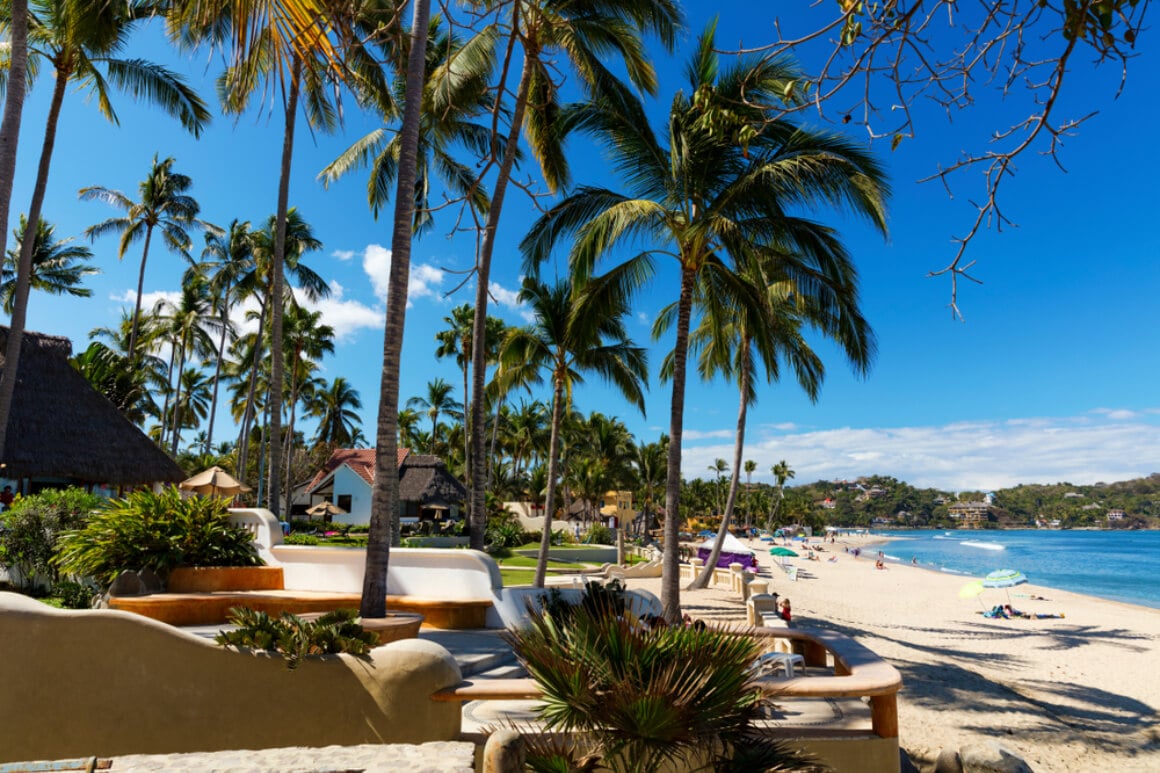 The shores of Nayarit, Mexico, featuring lounge chairs and palm trees along the beach