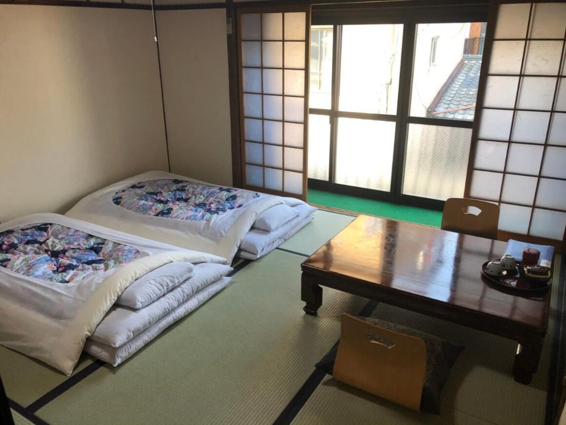 Room in a traditional Japanese inn (Takigawa Ryokan) with two futon beds and a small table.