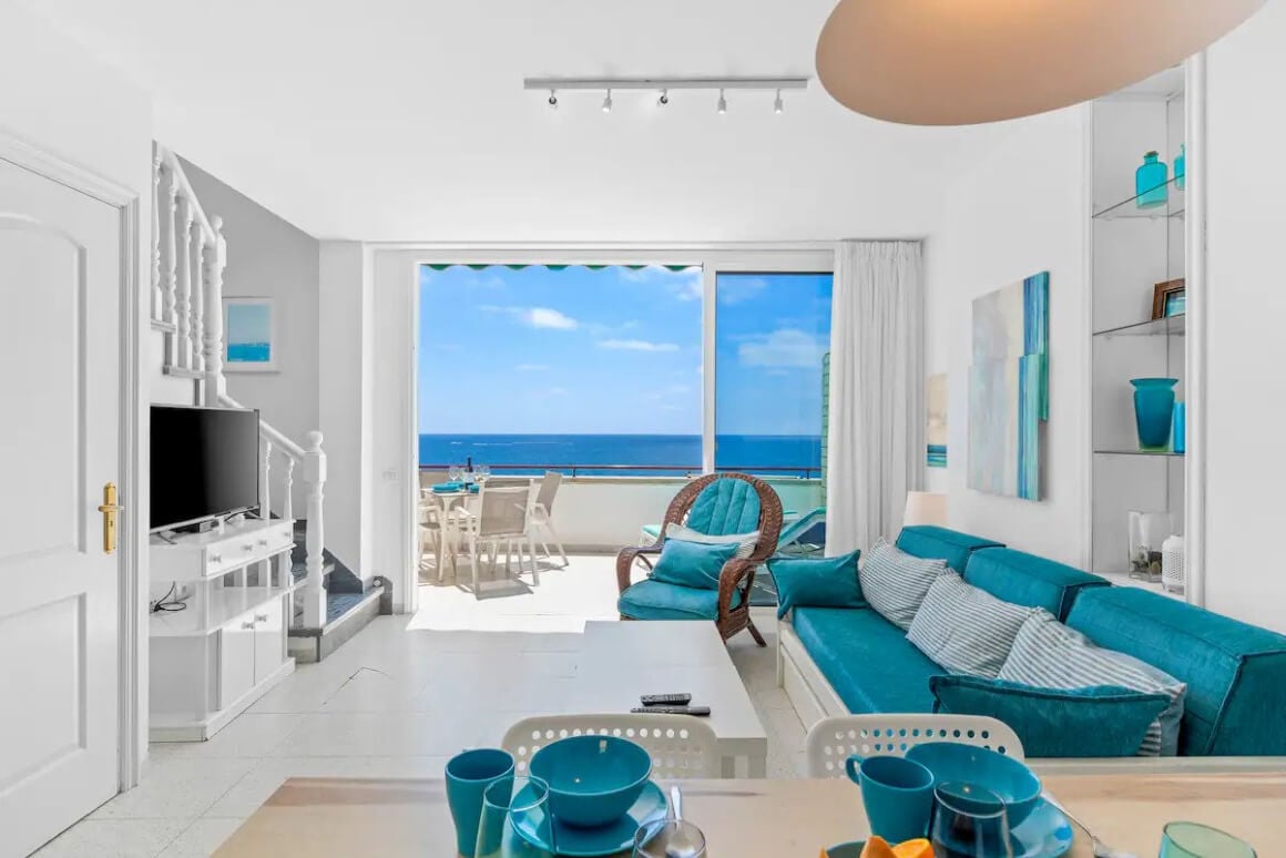 White and Blue living area at The First Line Sea View Penthouse with a view over the balcony to the ocean.